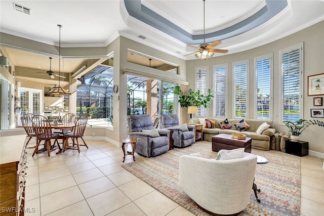 tiled living room with a raised ceiling, ceiling fan, and crown molding