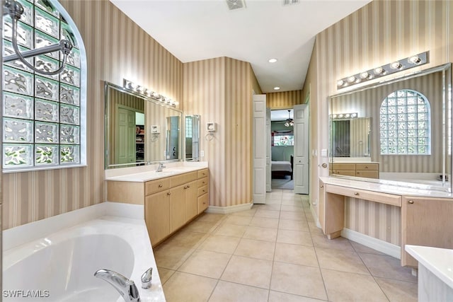 bathroom with tile patterned flooring, vanity, ceiling fan, and a tub