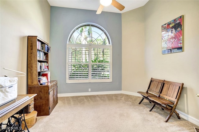 living area with ceiling fan and light carpet