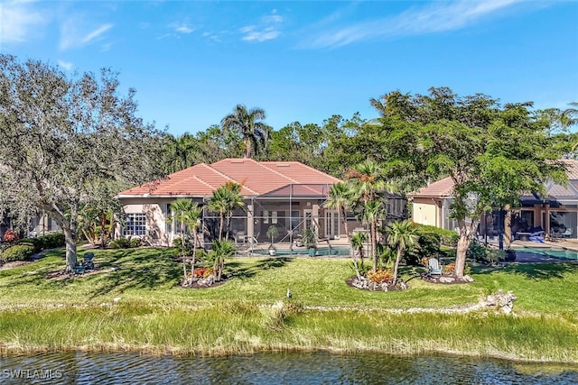 rear view of house with a lanai and a water view