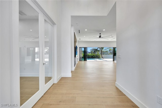 hallway with french doors and light hardwood / wood-style flooring