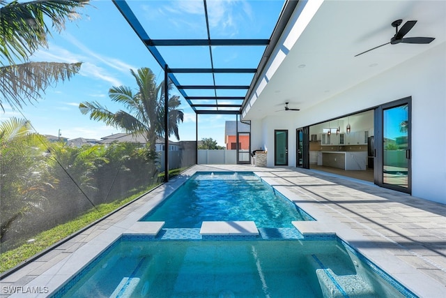 view of swimming pool featuring an in ground hot tub, a patio, ceiling fan, and a lanai