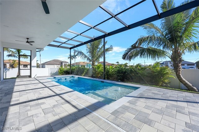 view of swimming pool featuring a patio, ceiling fan, and a lanai