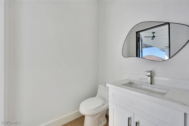 bathroom with tile patterned floors, vanity, ceiling fan, and toilet