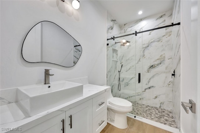 bathroom with vanity, a shower with shower door, and toilet