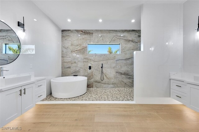 bathroom featuring hardwood / wood-style floors, vanity, and separate shower and tub