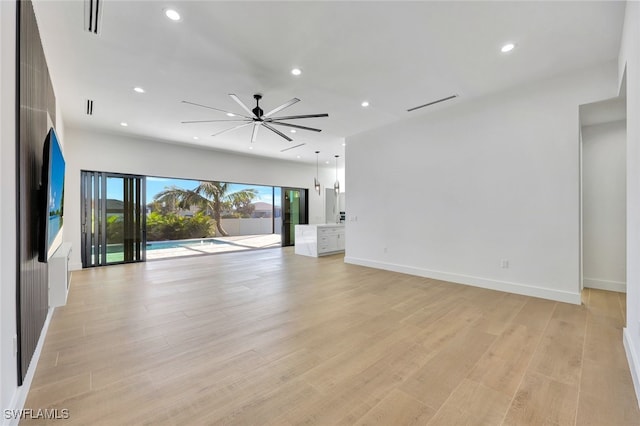 unfurnished living room with ceiling fan and light hardwood / wood-style flooring