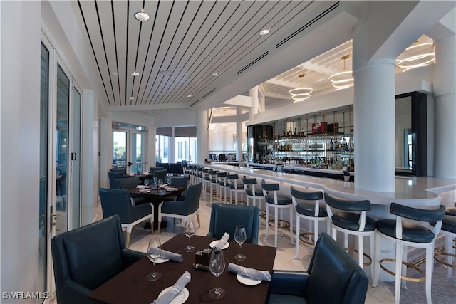 dining space with light tile patterned floors, wooden ceiling, and indoor bar