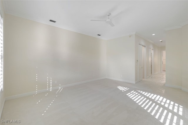 empty room featuring crown molding, ceiling fan, and light carpet