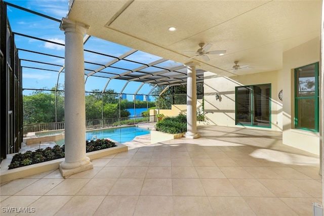 view of pool featuring glass enclosure, ceiling fan, and a patio area