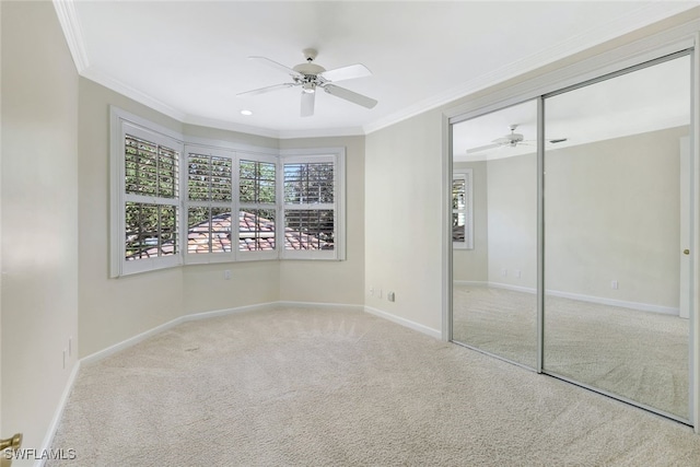 unfurnished bedroom featuring light carpet, a closet, ornamental molding, and ceiling fan