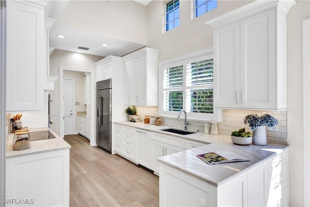 7817 Vizcaya Way, Naples, FL 34108 - kitchen with high end refrigerator, a sink, light wood-style floors, white cabinetry, and recessed lighting
