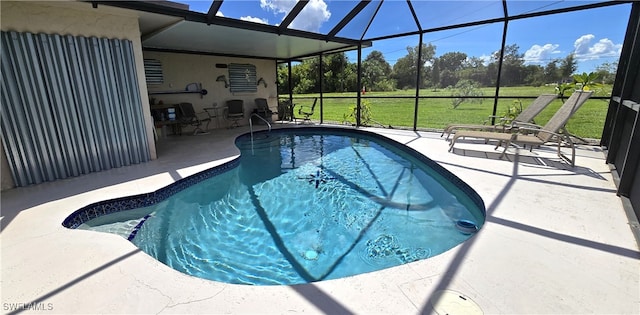 view of swimming pool with a patio, a lanai, and a lawn