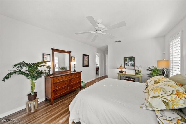 bedroom with multiple windows, wood-type flooring, and ceiling fan