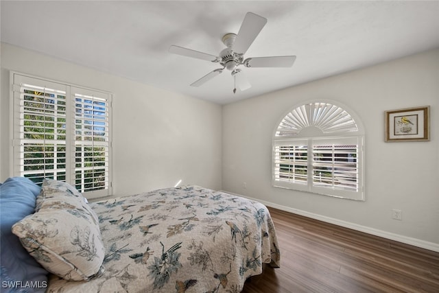 bedroom featuring multiple windows, ceiling fan, and dark hardwood / wood-style flooring