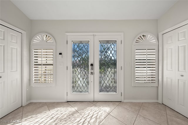 doorway with light tile patterned floors and french doors