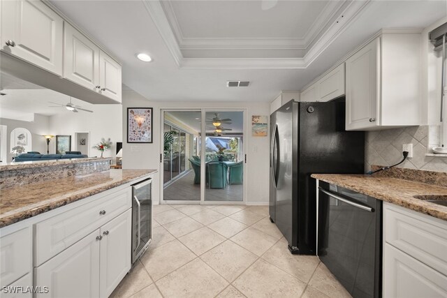 kitchen featuring white cabinetry, stainless steel appliances, a raised ceiling, tasteful backsplash, and light stone counters