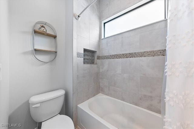 bathroom featuring tiled shower / bath and toilet