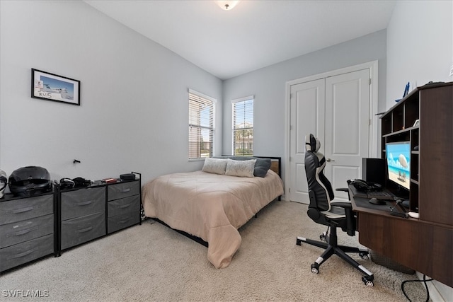 bedroom featuring light colored carpet and a closet