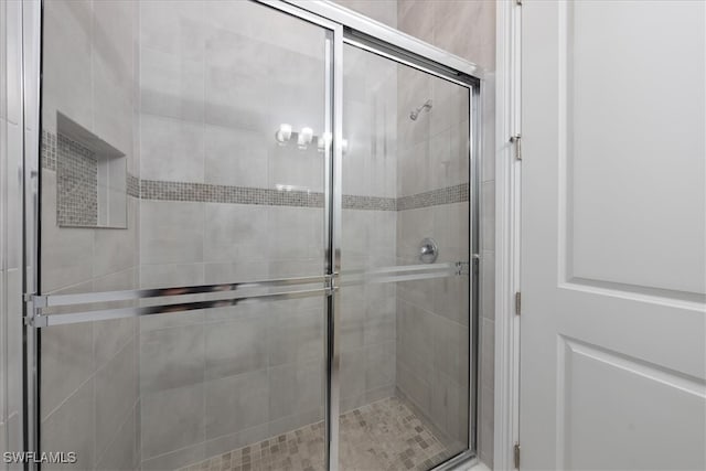 bathroom with a shower with door