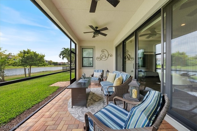 sunroom / solarium with a water view and ceiling fan