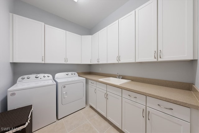 laundry room with sink, washer and clothes dryer, cabinets, and light tile patterned flooring