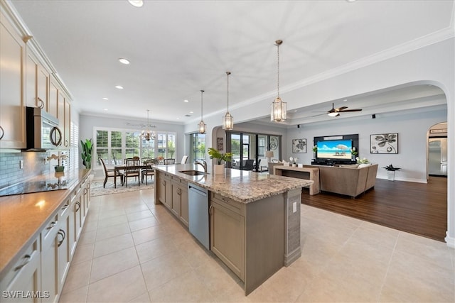 kitchen with appliances with stainless steel finishes, decorative light fixtures, a large island, light tile patterned floors, and light stone countertops