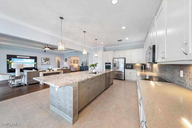 kitchen with light tile patterned floors, hanging light fixtures, stainless steel appliances, a spacious island, and white cabinets