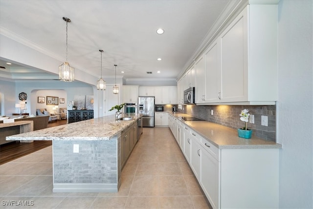 kitchen with light tile patterned flooring, decorative light fixtures, white cabinetry, a large island, and black appliances