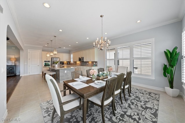 dining area with a notable chandelier, ornamental molding, and light tile patterned flooring