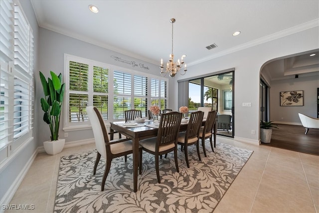 dining space featuring an inviting chandelier, crown molding, and light tile patterned flooring