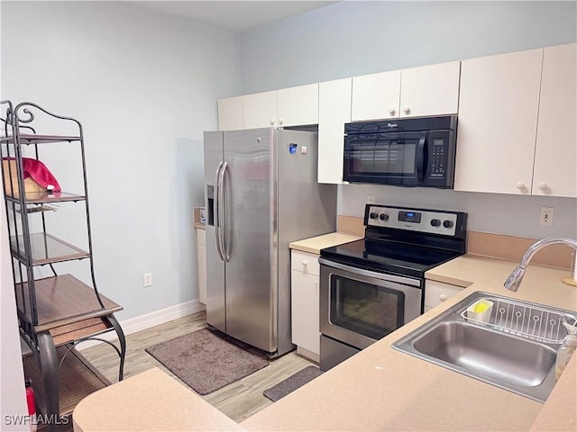 15393 Bellamar Cir Unit 522, Fort Myers, FL 33908 - kitchen with stainless steel appliances, light wood finished floors, a sink, light countertops, and white cabinetry