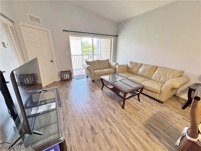 15393 Bellamar Cir Unit 522, Fort Myers, FL 33908 - living room with light wood finished floors, high vaulted ceiling, and baseboards