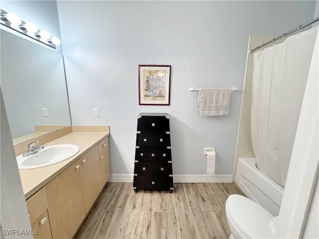 15393 Bellamar Cir Unit 522, Fort Myers, FL 33908 - full bathroom with vanity, wood finished floors, toilet, baseboards, and shower / bath combo with shower curtain