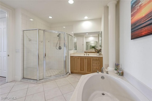 bathroom featuring tile patterned flooring, vanity, a shower with shower door, and ornate columns