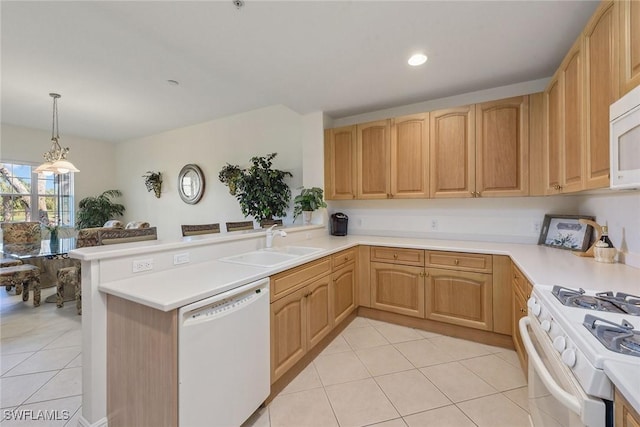 kitchen featuring kitchen peninsula, white appliances, sink, light brown cabinets, and decorative light fixtures