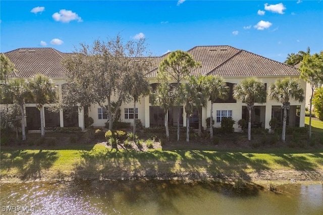 rear view of property featuring a yard and a water view