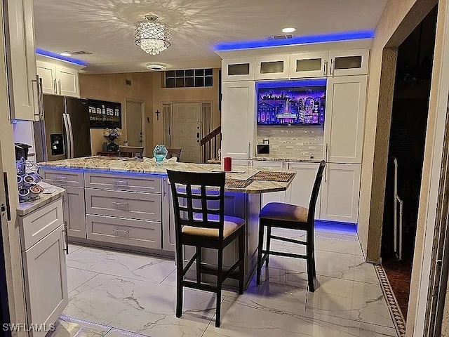 kitchen with a center island, white cabinets, and stainless steel refrigerator with ice dispenser