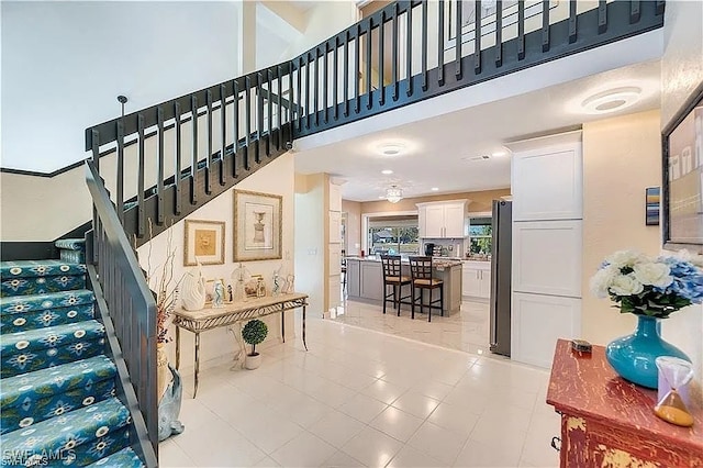 stairs with a high ceiling and tile patterned floors