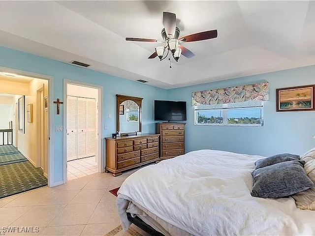 bedroom featuring multiple windows, light tile patterned flooring, a closet, and ceiling fan