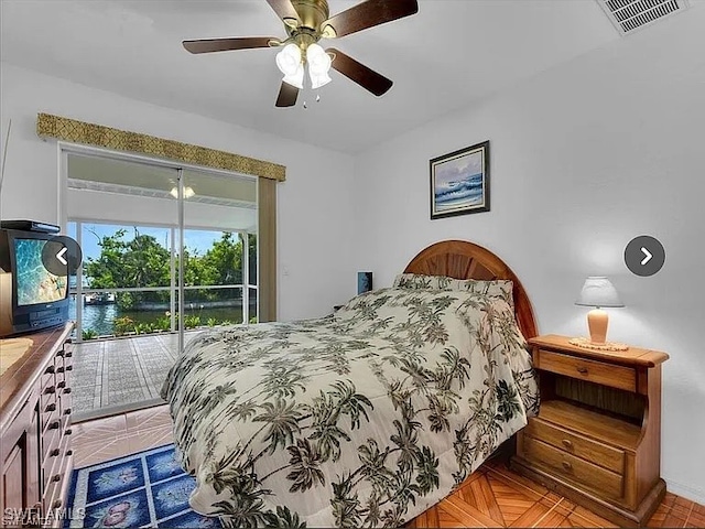 bedroom featuring ceiling fan, access to exterior, and parquet floors