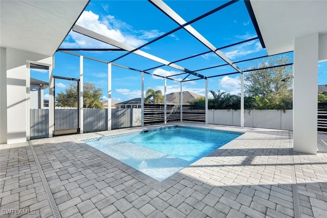 view of swimming pool featuring glass enclosure and a patio area