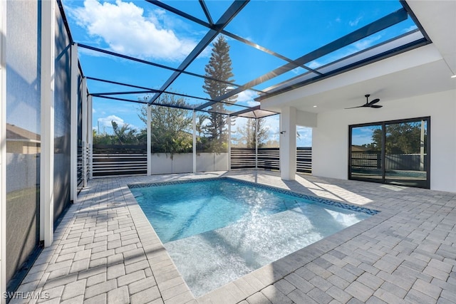 view of pool with glass enclosure, ceiling fan, and a patio area