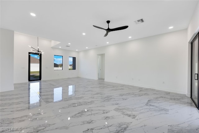 unfurnished living room with ceiling fan with notable chandelier