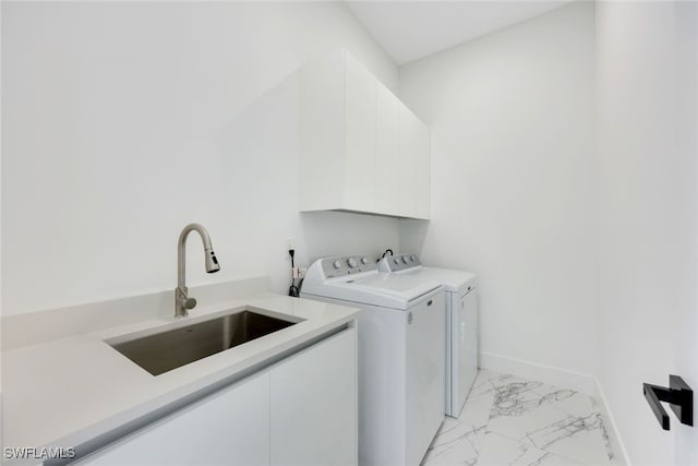 laundry area featuring washer and dryer, cabinets, and sink