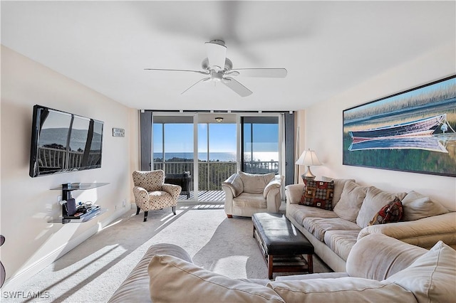 carpeted living room featuring ceiling fan and floor to ceiling windows