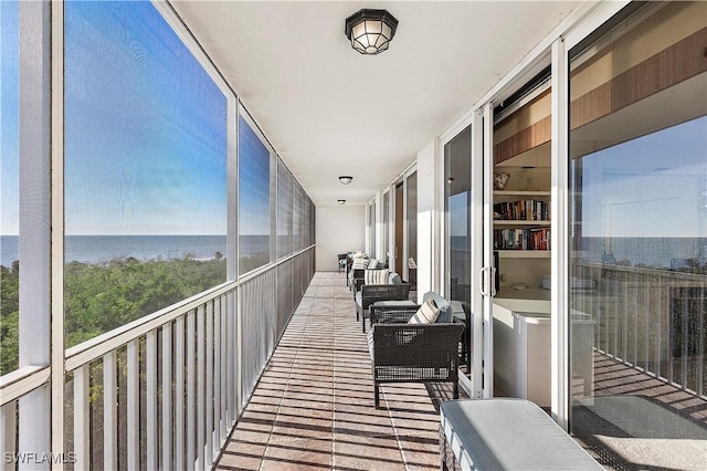 balcony featuring outdoor lounge area and a water view