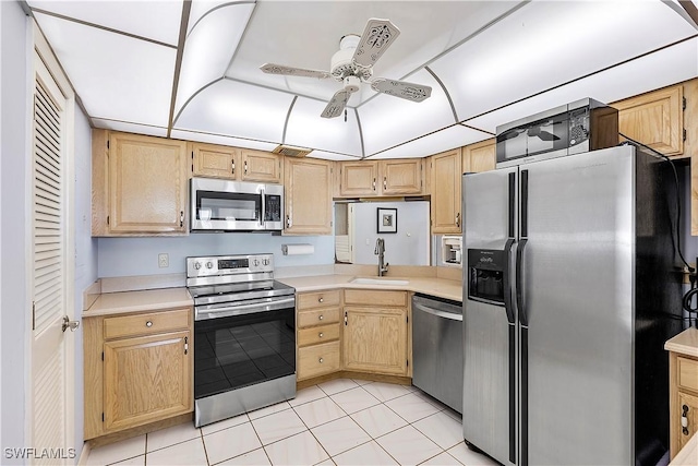 kitchen with stainless steel appliances, light brown cabinetry, sink, ceiling fan, and light tile patterned floors