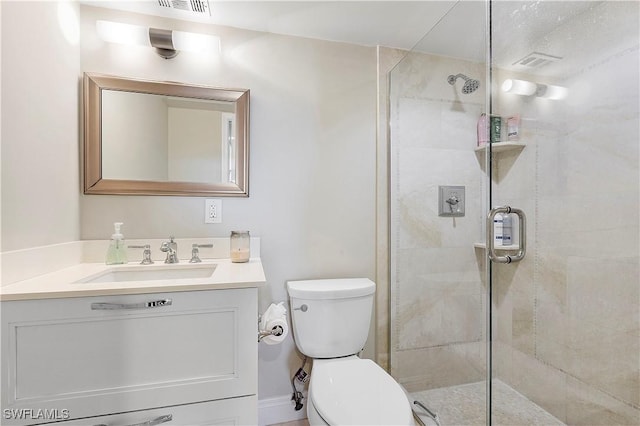 bathroom featuring toilet, a shower with door, and vanity