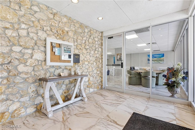 hallway featuring visible vents, recessed lighting, and marble finish floor